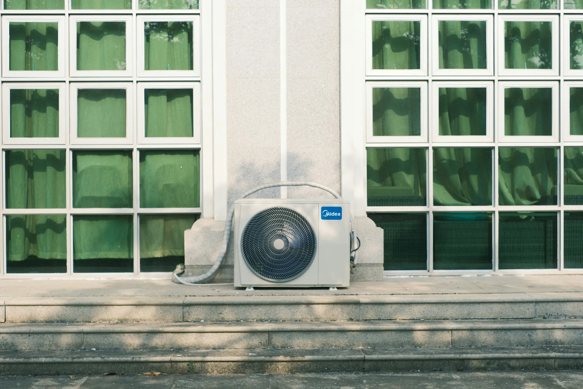 high-efficiency outdoor compressor unit installed outside a modern home - central ac vs ductless mini split comparison